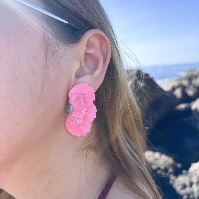 Detalle de pendiente de media flor coral en arcilla polimérica lucido en la oreja