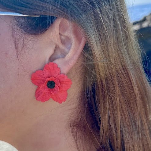 Detalle de pendiente Poppy Soul rojo en arcilla polimérica puesto en la oreja, talla M