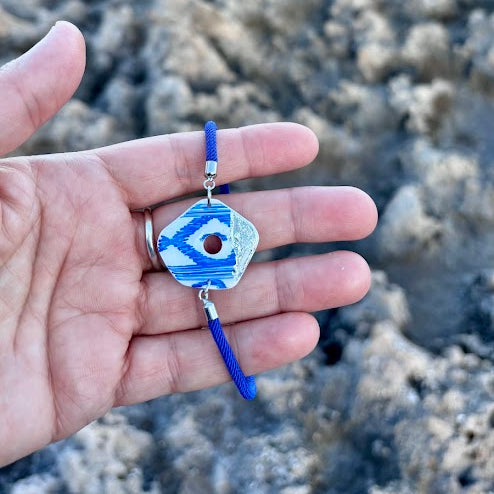 Primer plano de la pulsera de la colección Esencia Mallorquina sostenida en la mano, mostrando el acabado de la arcilla y el tamaño.