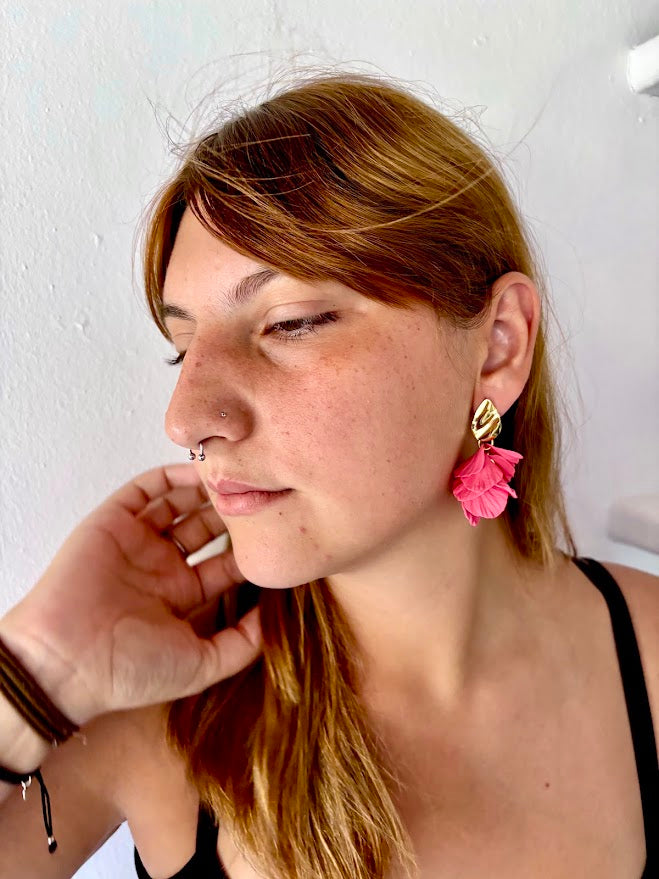 Pendientes artesanales de pétalos rosa coral en cascada con enganche dorado, lucidos por modelo