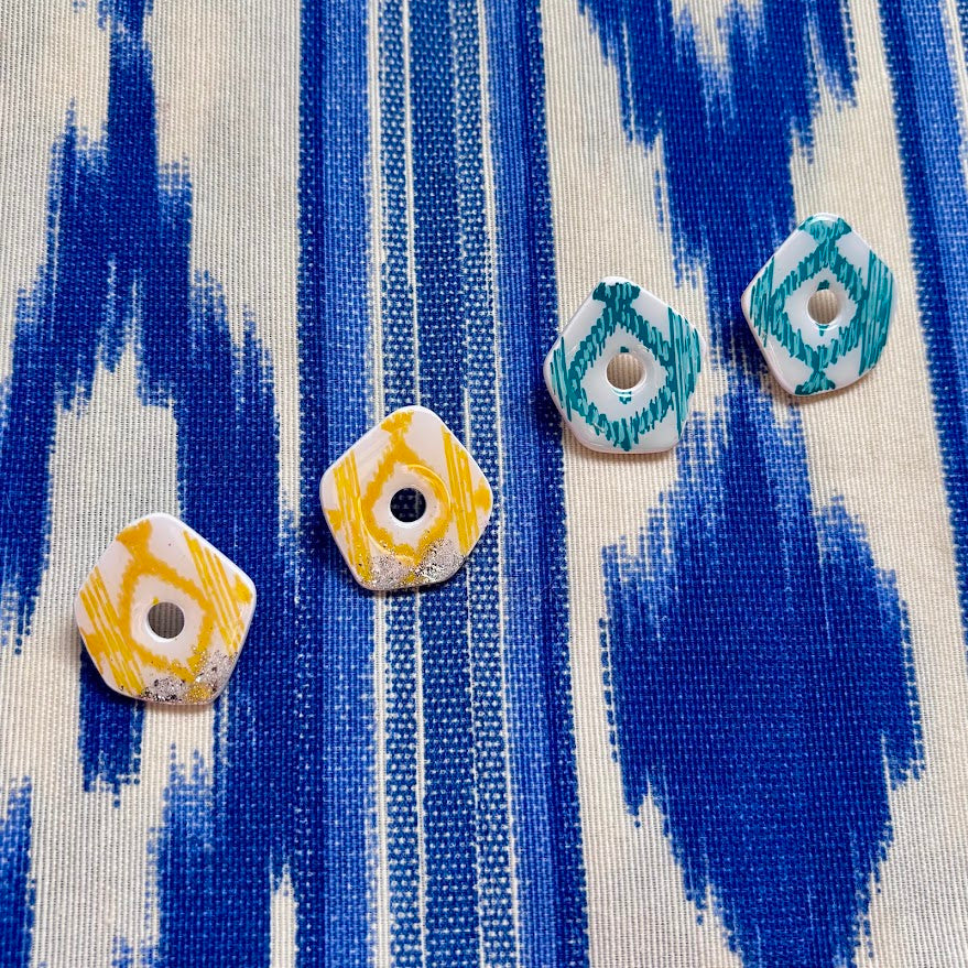 Pendientes Llengos Sol Stud M en amarillo y verde turquesa sobre tela de  llengos azul
