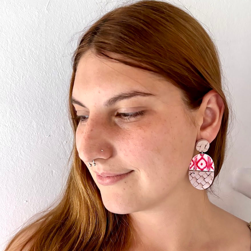 Modelo luciendo pendientes Arrels Foc de arcilla polimérica en tonos rojo y beige, diseño inspirado en la tela de llengos y la llata mallorquina