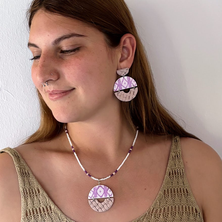 Modelo luciendo pendientes y collar artesanales Arrels Alba de arcilla polimérica en tonos lila y beige, colección Esencia Mallorquina de Pm_Art