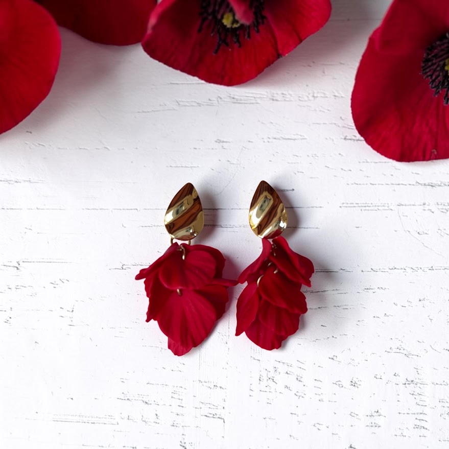 Pendientes de pétalos rojos en arcilla polimérica con enganche dorado, fotografía de producto sobre fondo blanco