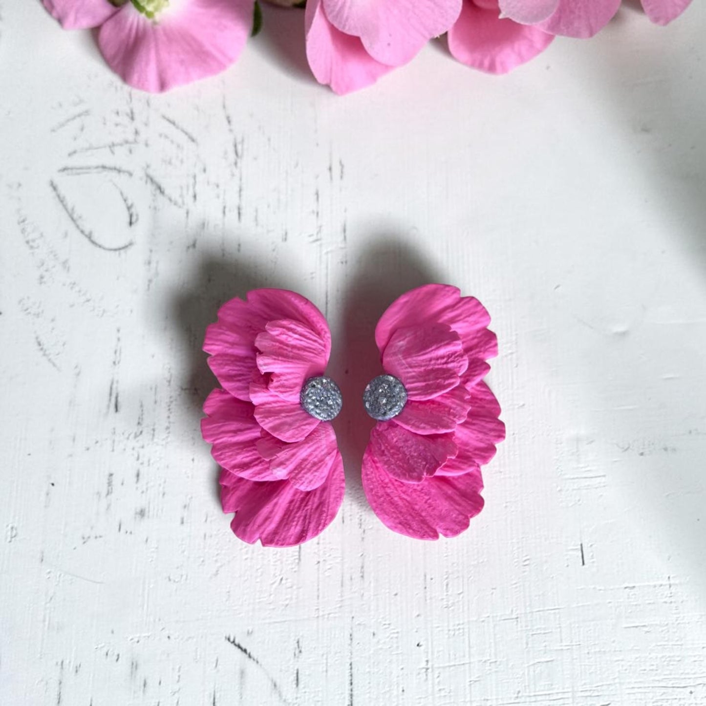 Pendientes de media flor en arcilla polimérica color coral, hechos a mano, sobre fondo blanco