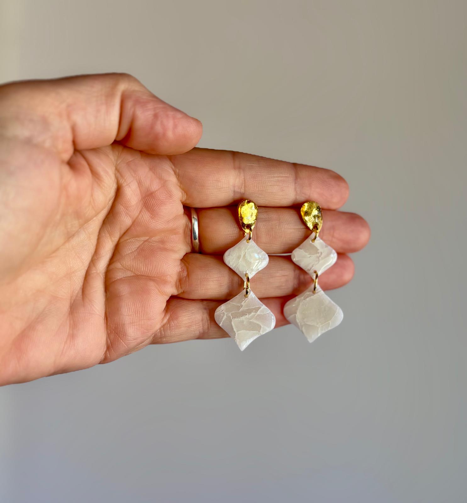 Pendientes geométricos artesanales Son Berga de arcilla polimérica efecto piedra natural con enganche dorado sostenidos en mano - joyería nupcial Mallorca
