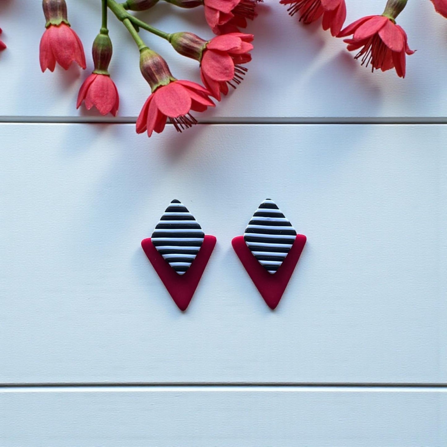 Pendientes de arcilla polimérica hechos a mano en Mallorca, con diseño geométrico en rojo y rombo de rayas blancas y negras