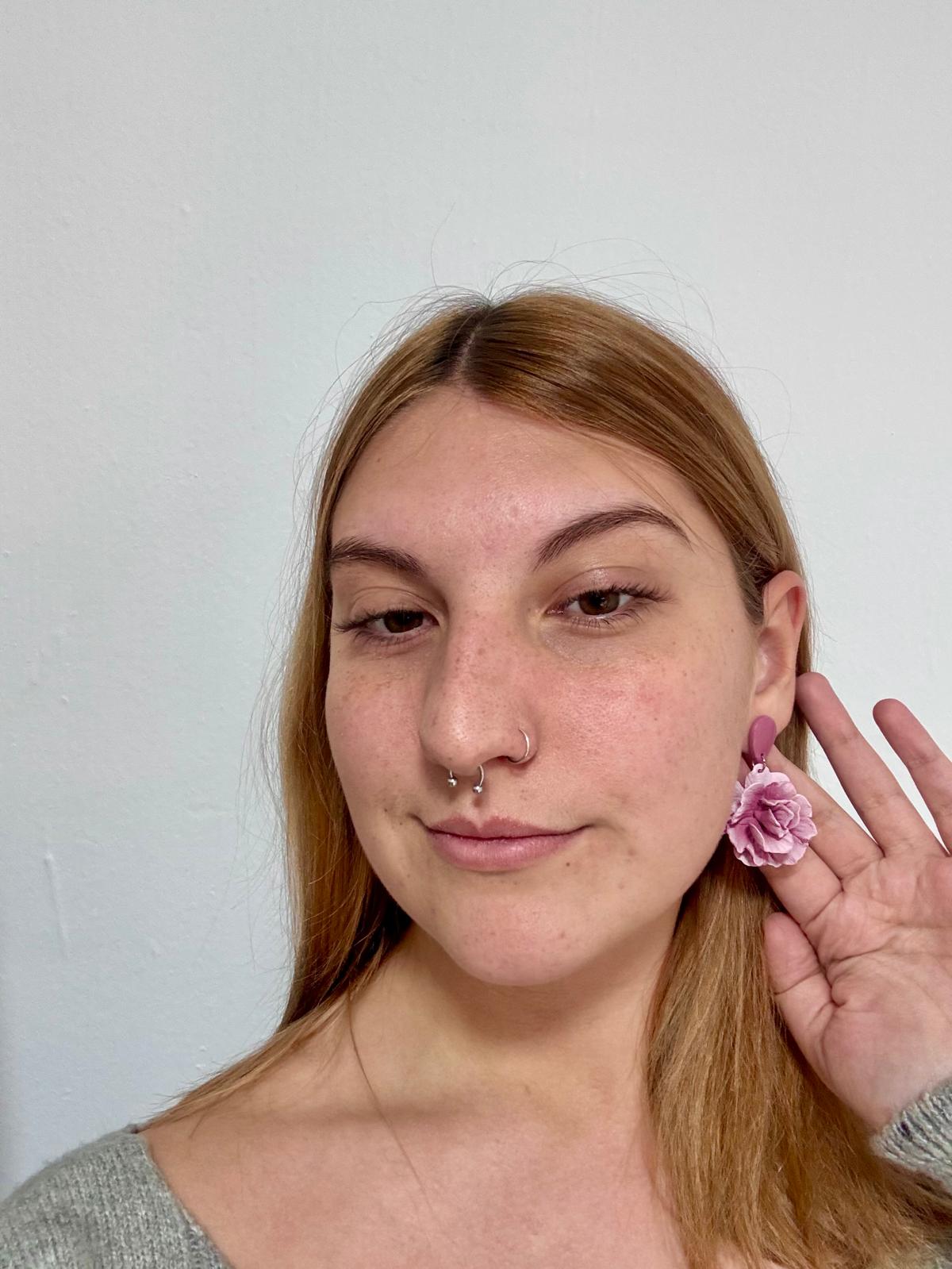 Mujer luciendo pendientes con forma de flor de arcilla polimerica artesanales inspirados en Mallorca