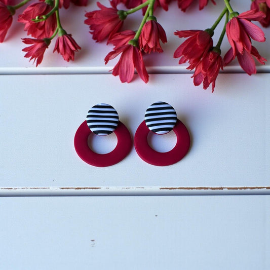Pendientes circulares de arcilla polimérica en color rojo con pieza superior redonda de rayas horizontales blancas y negras