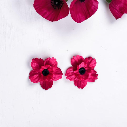 Pendientes de amapola artesanales en arcilla polimérica color rojo, hechos a mano, con flores naturales de fondo