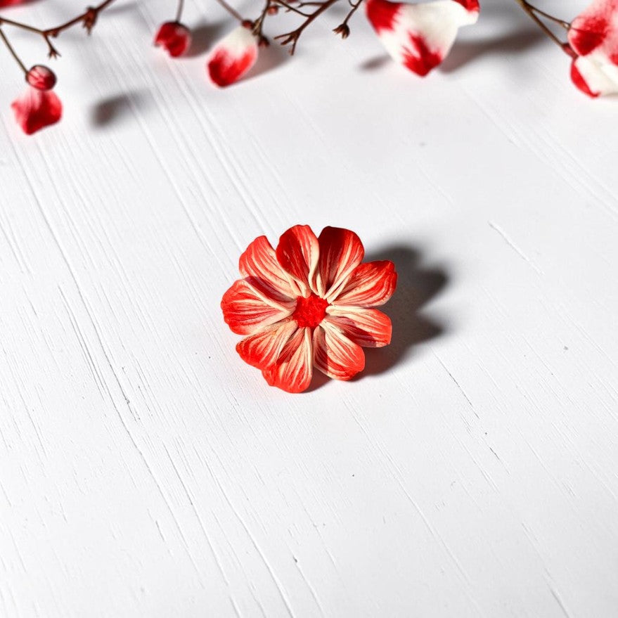 Vista frontal anillo flor en tonos rojo y blanco, de arcilla polimérica hecho a mano