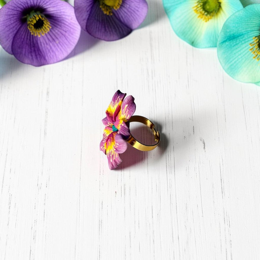 Vista lateral anillo flor en tonos morado y amarillo, de arcilla polimérica, joyería artesanal