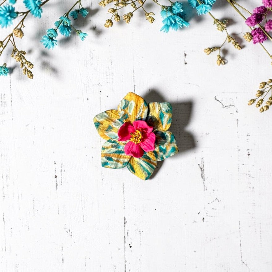 Anillo de arcilla polimérica hecho a mano con estampado en tonos turquesa y dorado, centro de la flor en color fucsia y dorado. Joyería artesanal.