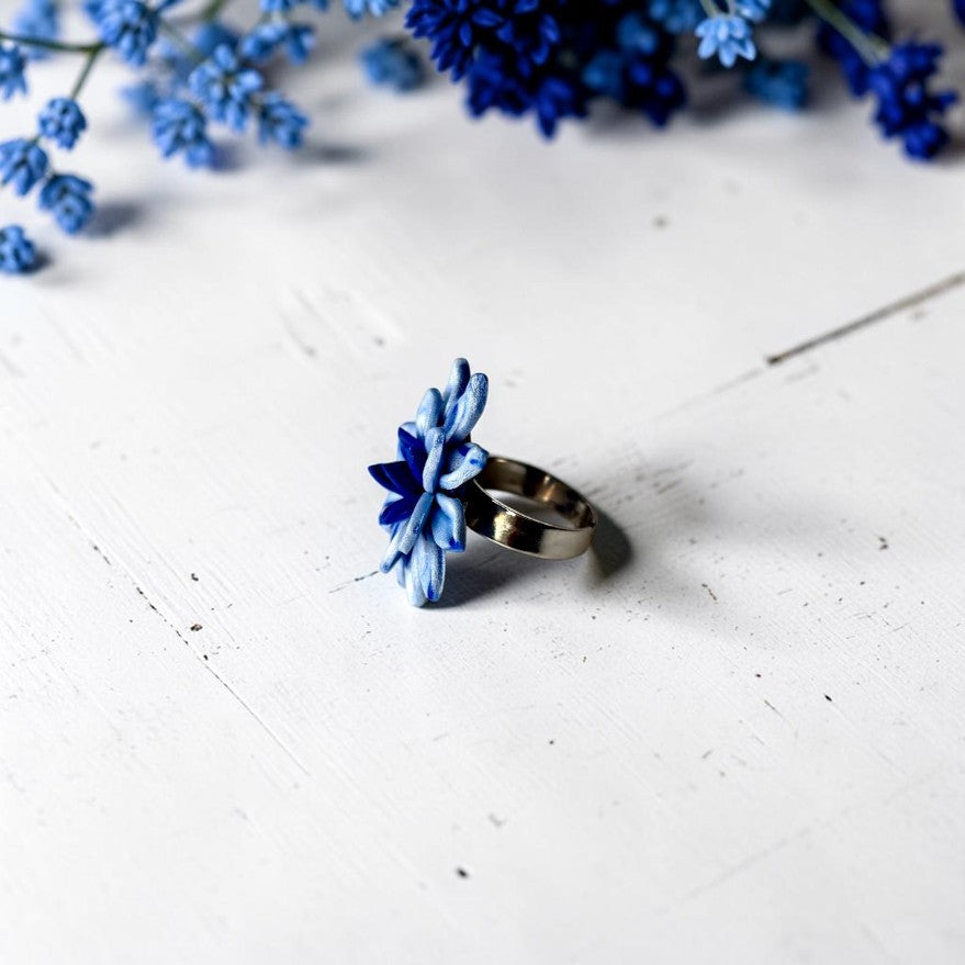 Vista lateral anillo flor color azul claro y azul oscuro, de arcilla polimérica. Joyería artesanal.