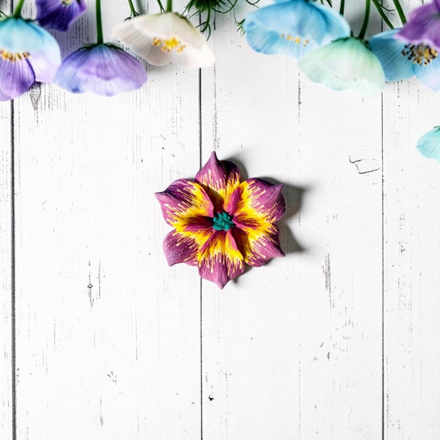 Vista fronal anillo flor color morado y amarillo, centro turquesa, hecho a mano con arcilla polimérica