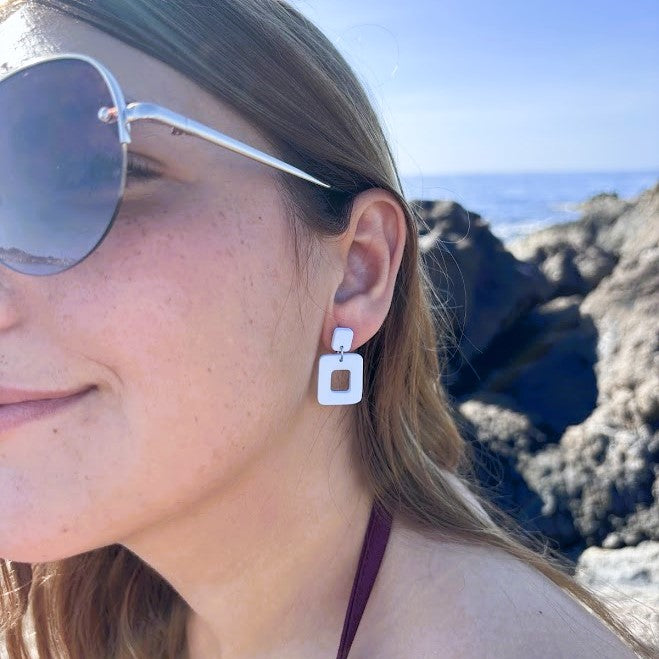 Pendientes Cubuk azul nube de arcilla polimérica, detalle en oreja con fondo de playa y rocas
